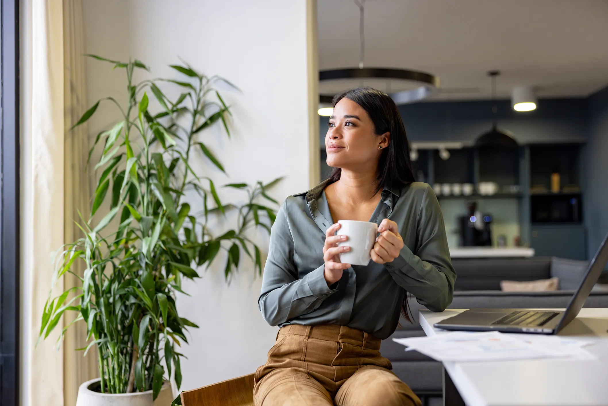 woman with her coffee working on laptop