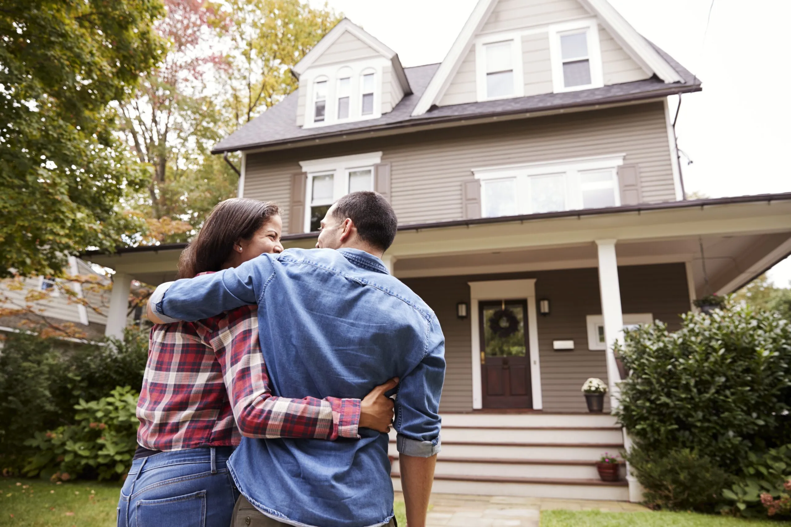 couple in front of newly purchased home