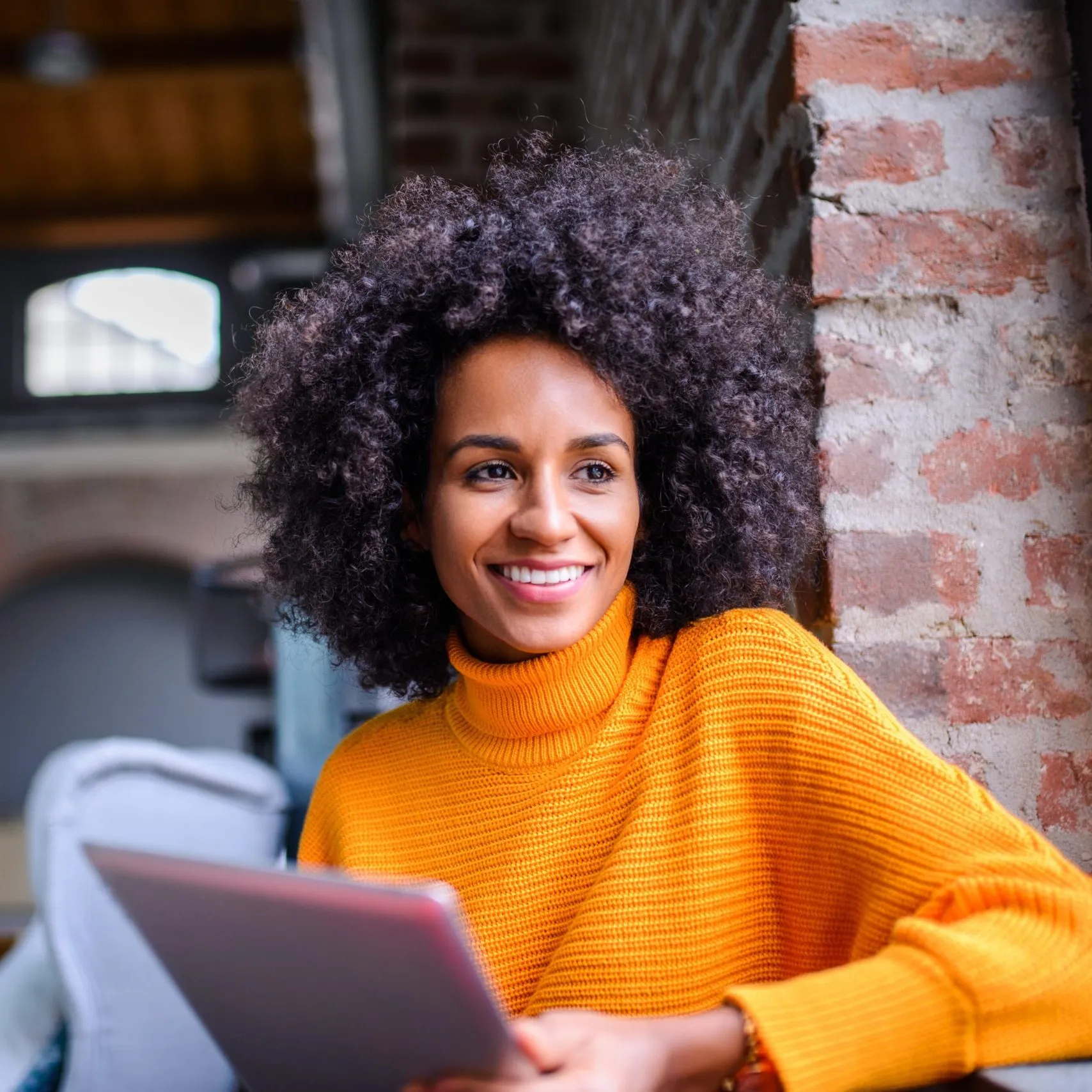 woman smiling on tablet in coffee shop